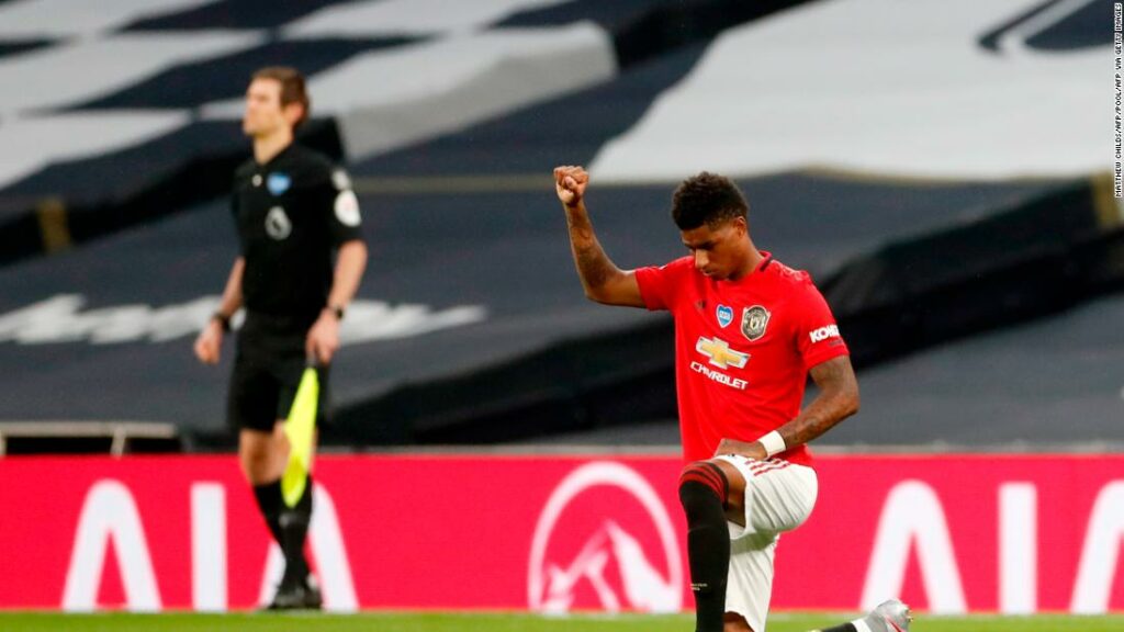 Marcus Rashford takes a knee and raises his fist as he pulls out Manchester United