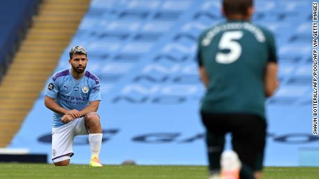 Manchester City striker Sergio Aguero (L) and Burnley defender James Tarkowski kneel in support of the Black Lives Matter movement.