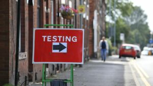 A sign shows where to turn to enter a COVID-19 testing centre in Oldham, Greater Manchester