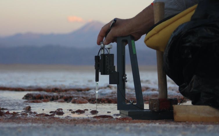 Peter Fisher uses field equipment to measure the chemical composition of purple microbial mats.