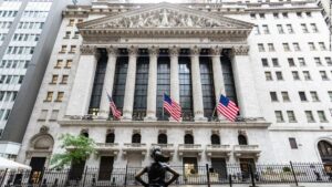 A face mask is seen in front of the New York Stock Exchange (NYSE) on May 26, 2020 at Wall Street in New York City. - Global stock markets climbed Monday, buoyed by the prospect of further easing of coronavirus lockdowns despite sharp increases in case rates in some countries such as Brazil. Over the weekend, US President Donald Trump imposed travel limits on Brazil, now the second worst affected country after the United States, reminding markets that while the coronavirus outlook is better, the crisis is far from over. (Photo by Johannes EISELE / AFP) (Photo by JOHANNES EISELE/AFP via Getty Images)