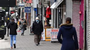 Pedestrians wearing protective face masks walk past shops in the Handsworth area of Birmingham, central England on August 22, 2020, as Britain's second-city, home to more than one million people, was made an "area of enhanced support", because of concern about a spike in cases of the novel coronavirus. (Photo by JUSTIN TALLIS / AFP) (Photo by JUSTIN TALLIS/AFP via Getty Images)